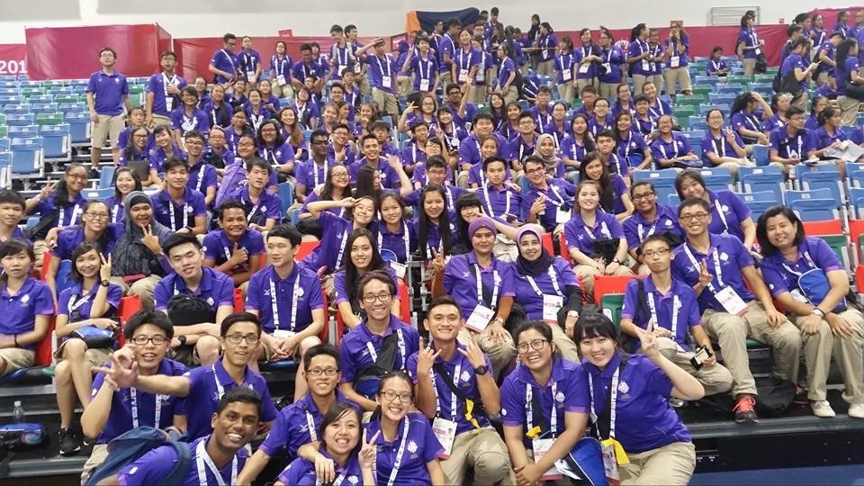 CharB with SEA Games volunteers in purple shirts at a stadium